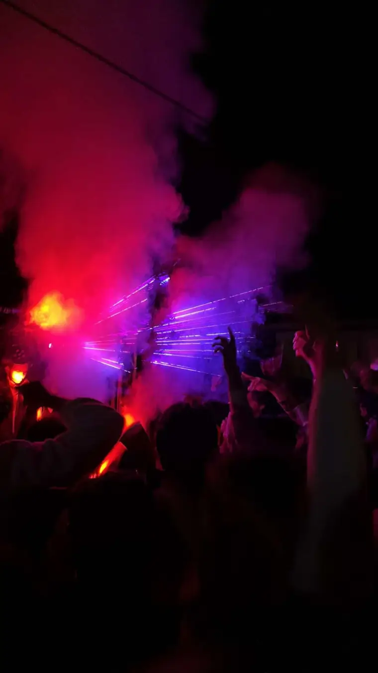 Red and purple lights above a nighttime crowd