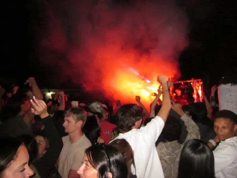 Dance floor filled with people and red smoke