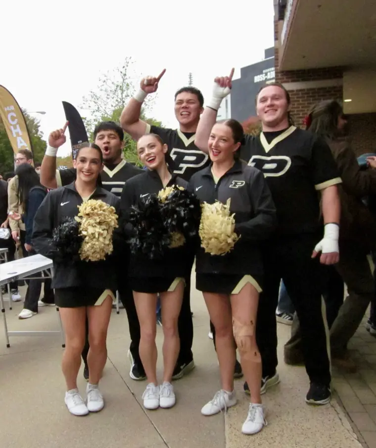 Purdue cheerleaders and guests celebrating at a daytime event